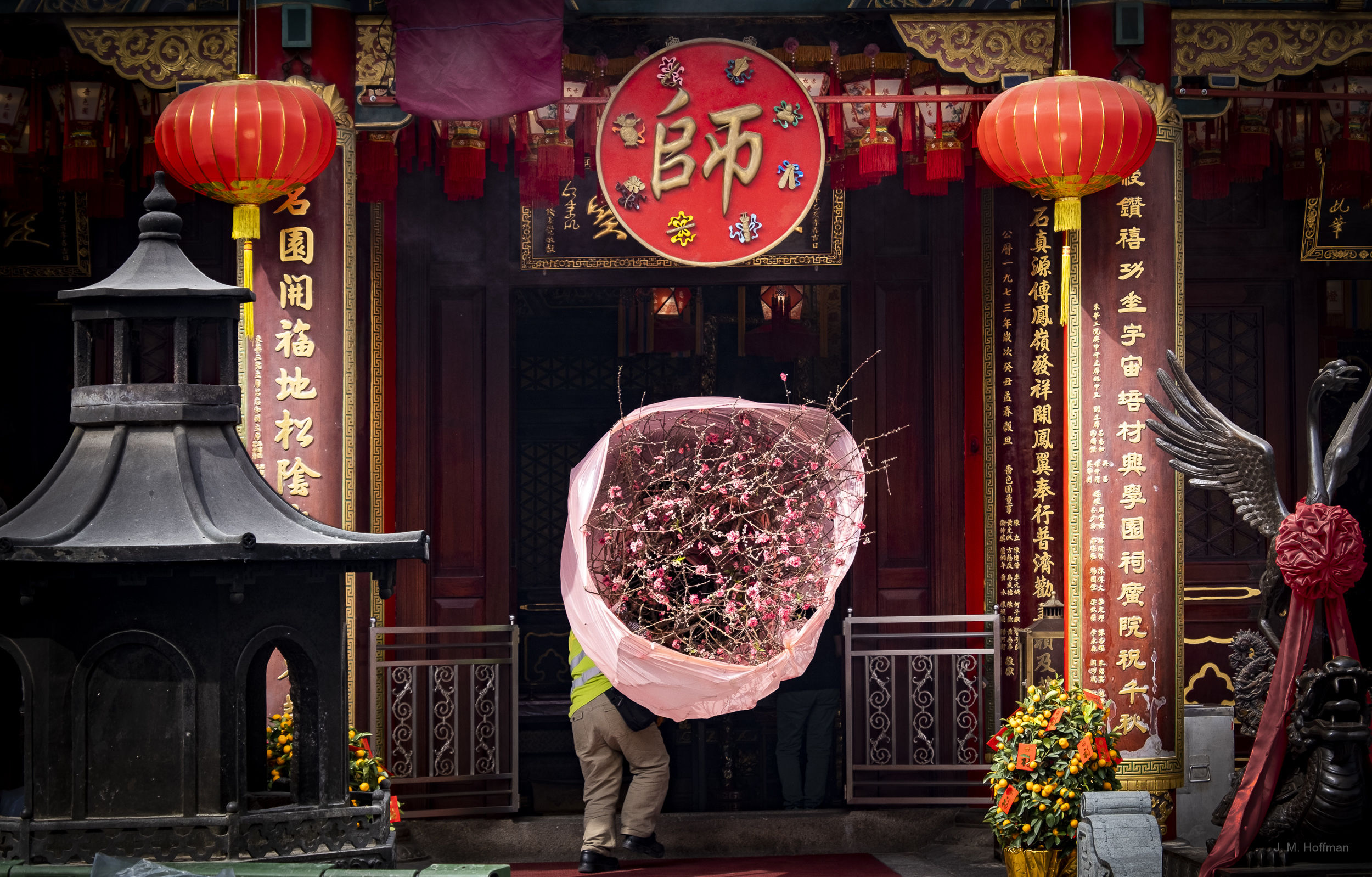 A worker brings flowers into the Taoist Wong Tai Sin Temple ahead of the Chinese New Year.: Kowloon, Hong Kong